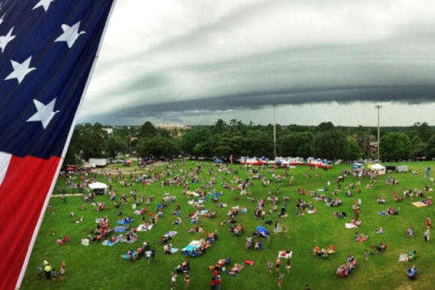 In a panoramic photo, a crowd of students and residents gathers beneath an impending storm on campus at Flavet Field for UF’s Fanfares &amp; Fireworks event &nbsp;in 2013.
&nbsp;