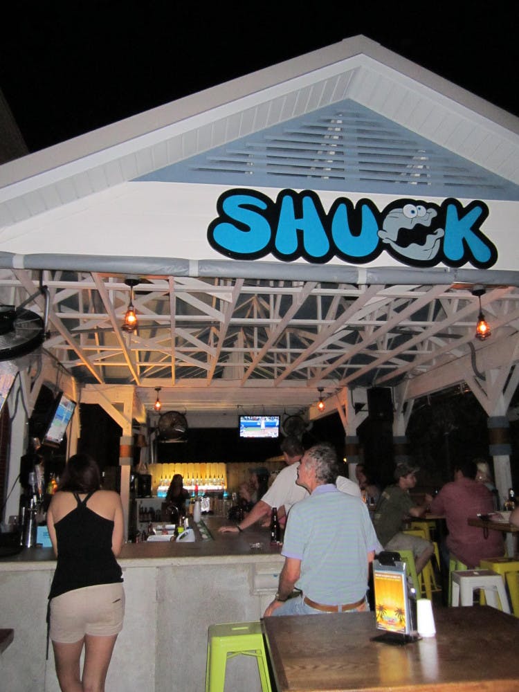 Customers at Shuck Raw Bar and Restaurant in Midtown sit outside watching TV at the bar and chatting among friends. They can enjoy seafood and drinks there and a free shot at sunset.