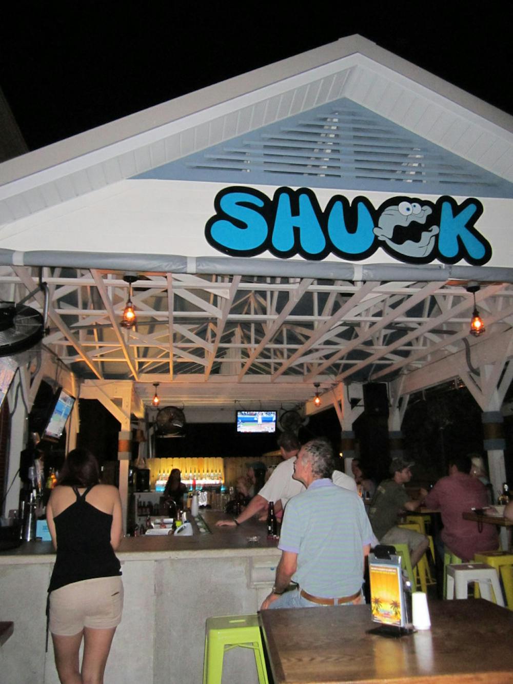 <p>Customers at Shuck Raw Bar and Restaurant in Midtown sit outside watching TV at the bar and chatting among friends. They can enjoy seafood and drinks there and a free shot at sunset.</p>