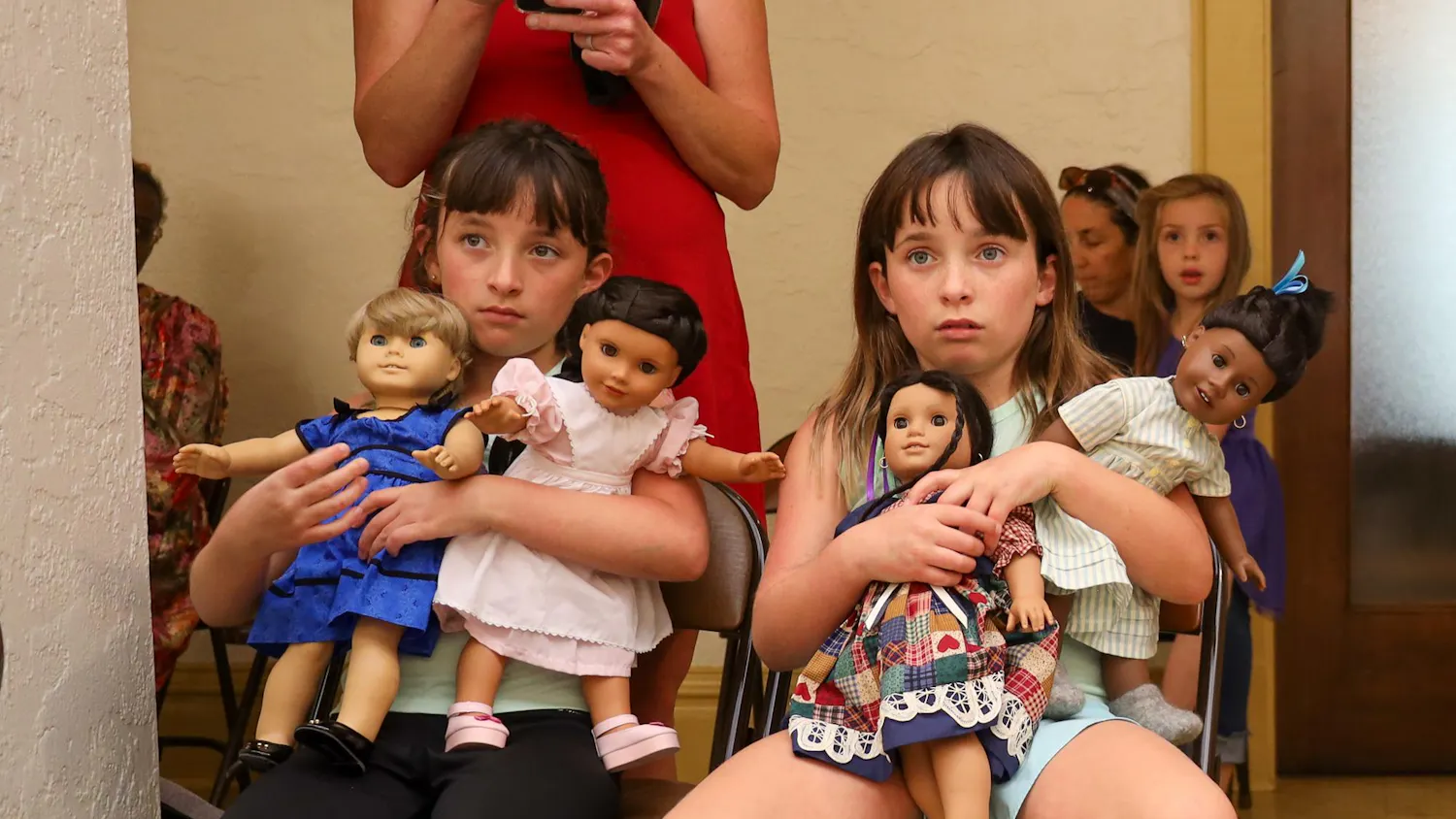 Justine (left) and Riley (right) hold their American Girl Dolls and watch a play at the Thomas Center in Gainesville, Fla., Saturday March 29, 2026.