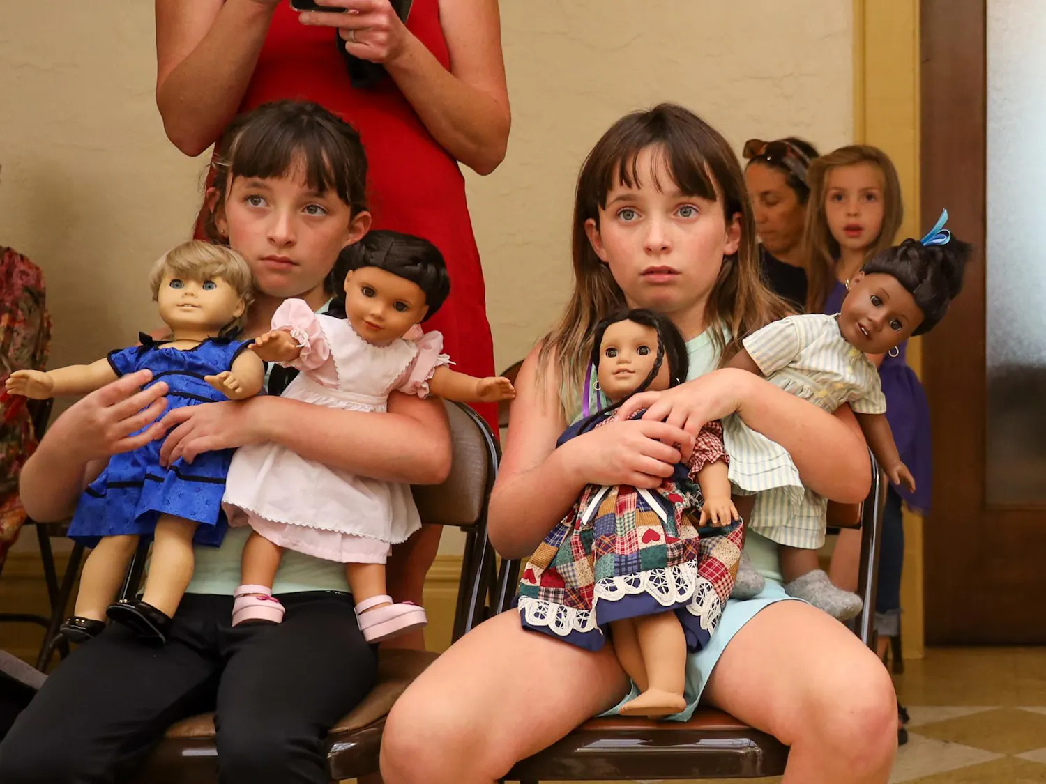 Justine (left) and Riley (right) hold their American Girl Dolls and watch a play at the Thomas Center in Gainesville, Fla., Saturday March 29, 2026.