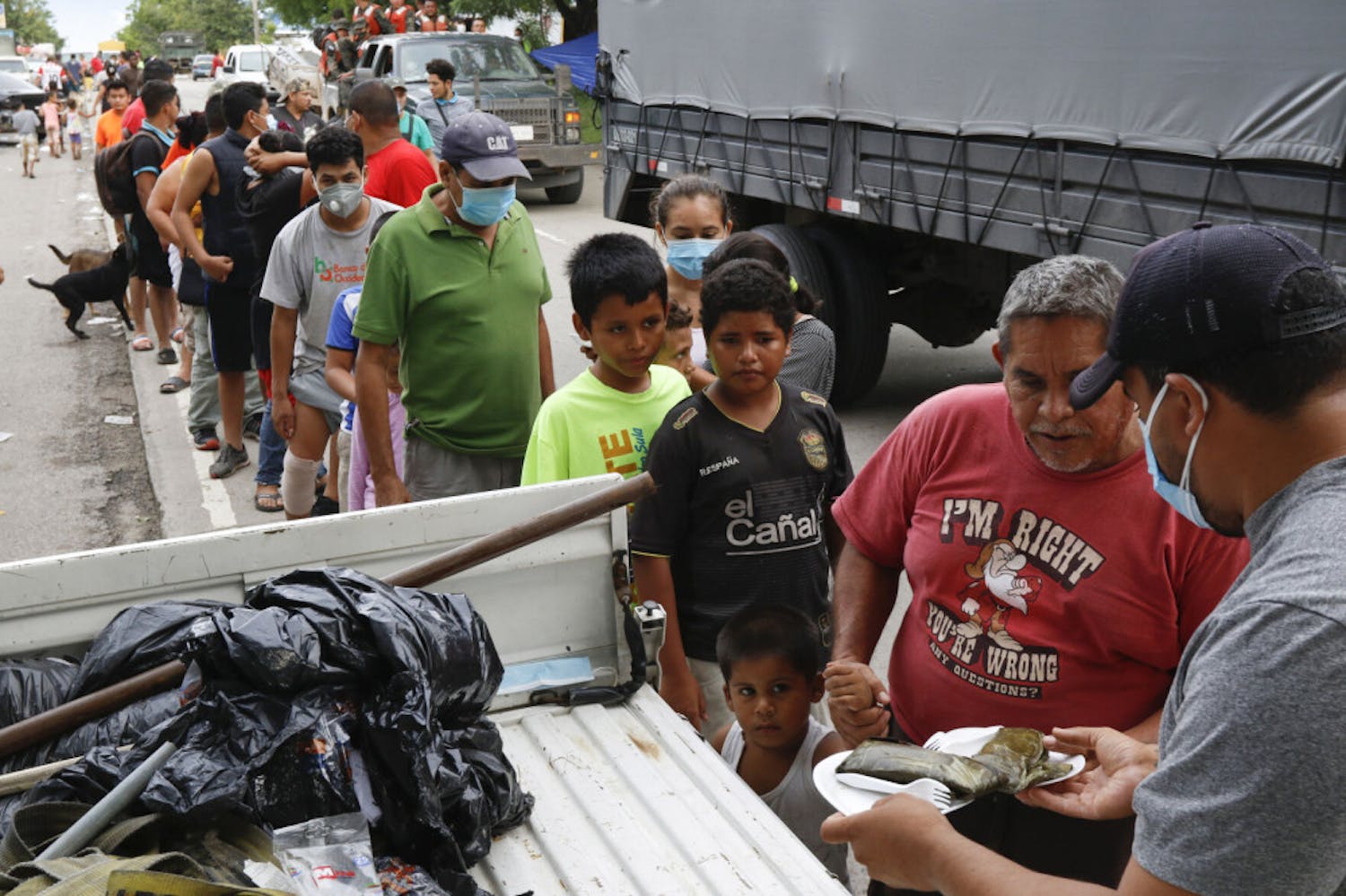 Residents affected by Hurricane Eta stand in a line to receive donated food in Planeta, Honduras, Friday, Nov. 6, 2020. As the remnants of Eta moved back over Caribbean waters, governments in Central America worked to tally the displaced and dead, and recover bodies from landslides and flooding that claimed dozens of lives from Guatemala to Panama.