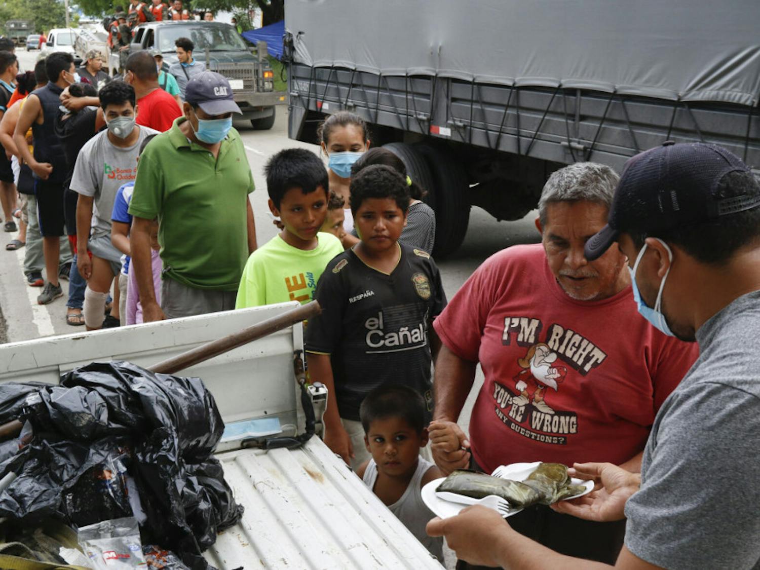 Residents affected by Hurricane Eta stand in a line to receive donated food in Planeta, Honduras, Friday, Nov. 6, 2020. As the remnants of Eta moved back over Caribbean waters, governments in Central America worked to tally the displaced and dead, and recover bodies from landslides and flooding that claimed dozens of lives from Guatemala to Panama.