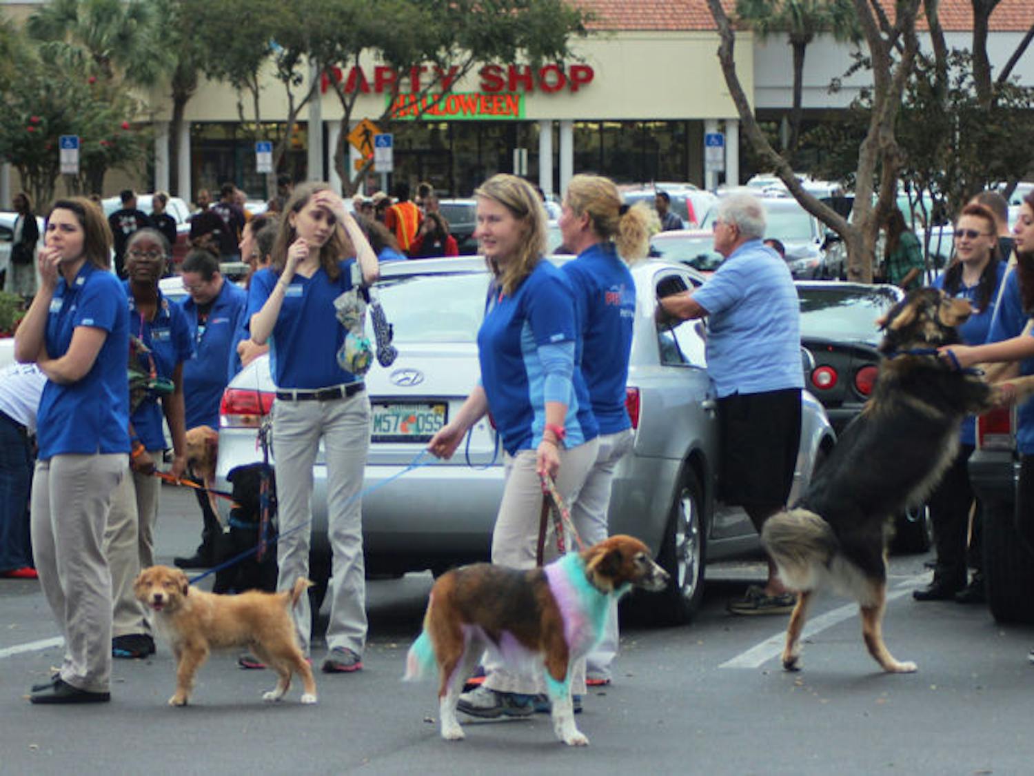 PetSmart employees and dogs stand in the parking lot after evacuating Monday while Gainesville Fire Rescue and Alachua County Fire Rescue work to extinguish the fire.