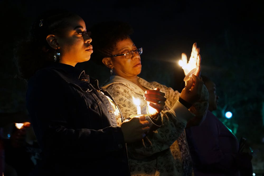 <p>Two women attempt to keep their candles lit at a vigil held for Marcus Goodman, an inmate who died in the Alachua County Jail, at Bo Diddley Plaza Thursday, Feb. 2, 2023.</p>
