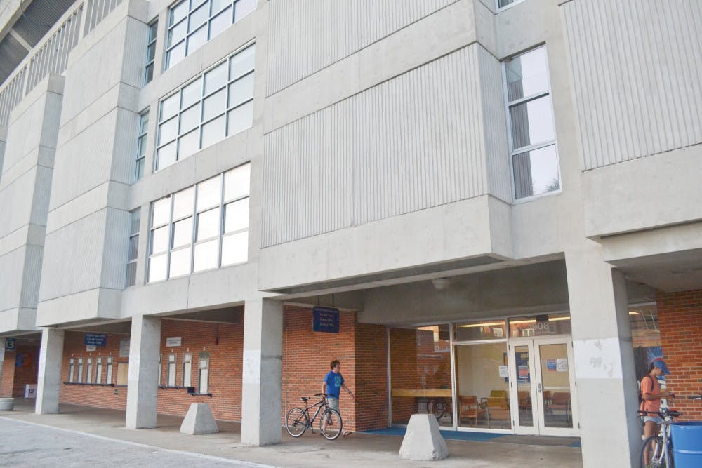 Jamie Harshman, a 21-year-old UF business and mechanical engineering senior, walks his bicycle to the bike rack located at the entrance of Yon Hall September 8, 2015.