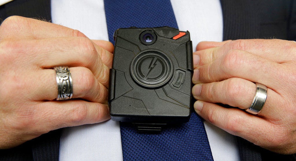In this Feb. 19, 2015 file photo, Steve Tuttle, vice president of communications for Taser International, demonstrates one of the company's body cameras during a company-sponsored conference at the California Highway Patrol headquarters in Sacramento, Calif.&nbsp;