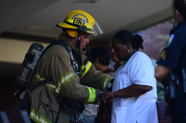 Gainesville firefighter/paramedic Matt Pfost checks the blood pressure of UF employee Stephanie Bennett-White in Turlington after the building was evacuated because of a chemical spill on Monday afternoon.