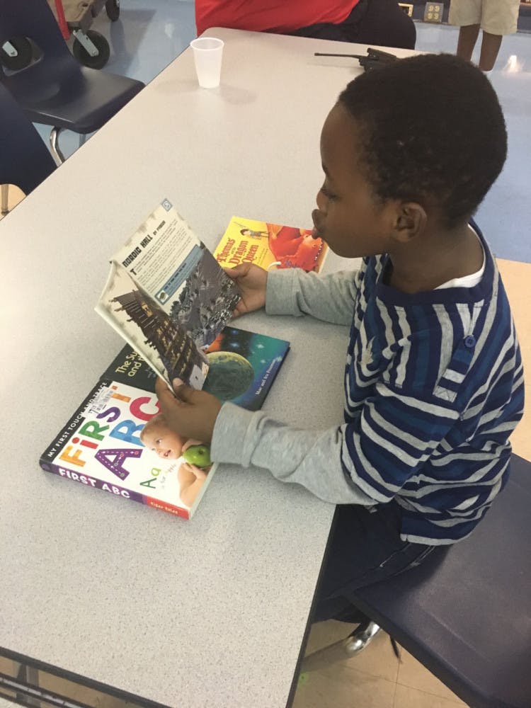 Seven-year-old Jakhari McFadden admires the Nordic Hall design in his new “Minecraft: Essential Handbook.” The second-grader and every student at Sidney Lanier Elementary School now has access to free books with the school’s new book house, which was unveiled at about 11 a.m. Tuesday in the cafeteria.
