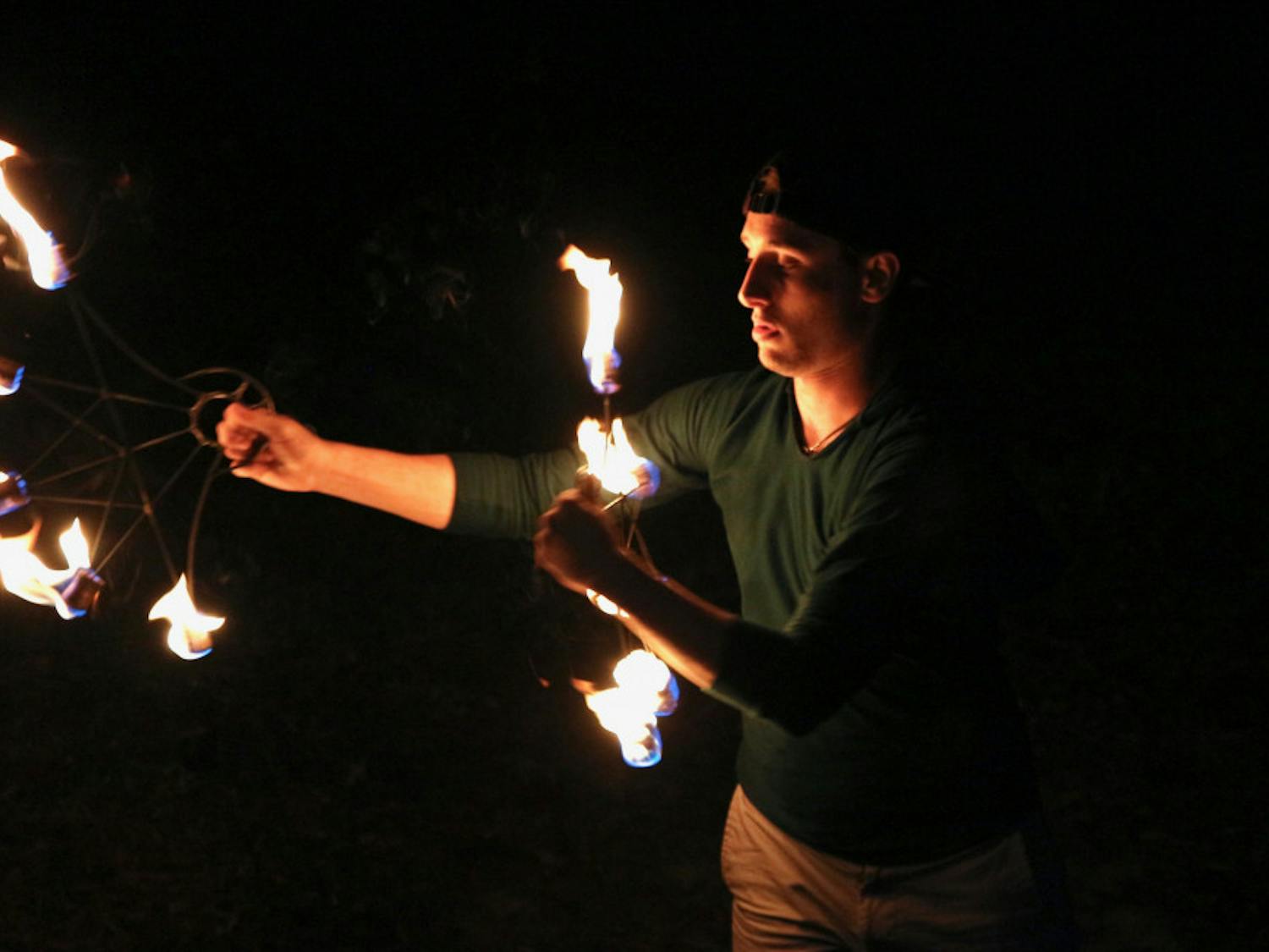 Sam Konchan, 21, UF botany junior spins a set of fire fans in the backyard area of Flow Space located on 117 NW 16th Ave. Spinning fire is only one form of the flow arts in which Konchan also finds a community offering lifelong friendships.