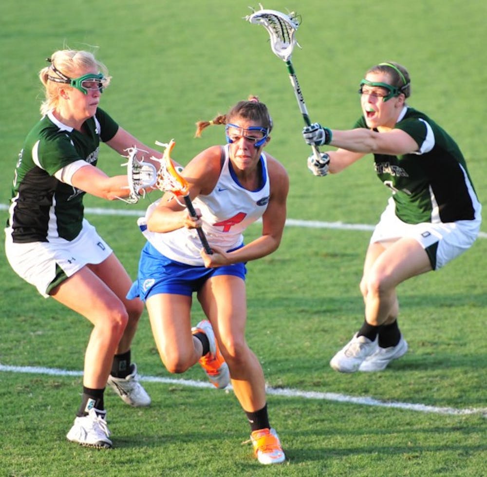 <p>Florida attacker Kitty Cullen splits two Dartmouth defenders while attacking the goal during the Gators’ 20-4 win against the Big Green on Tuesday. Cullen scored five goals.</p>