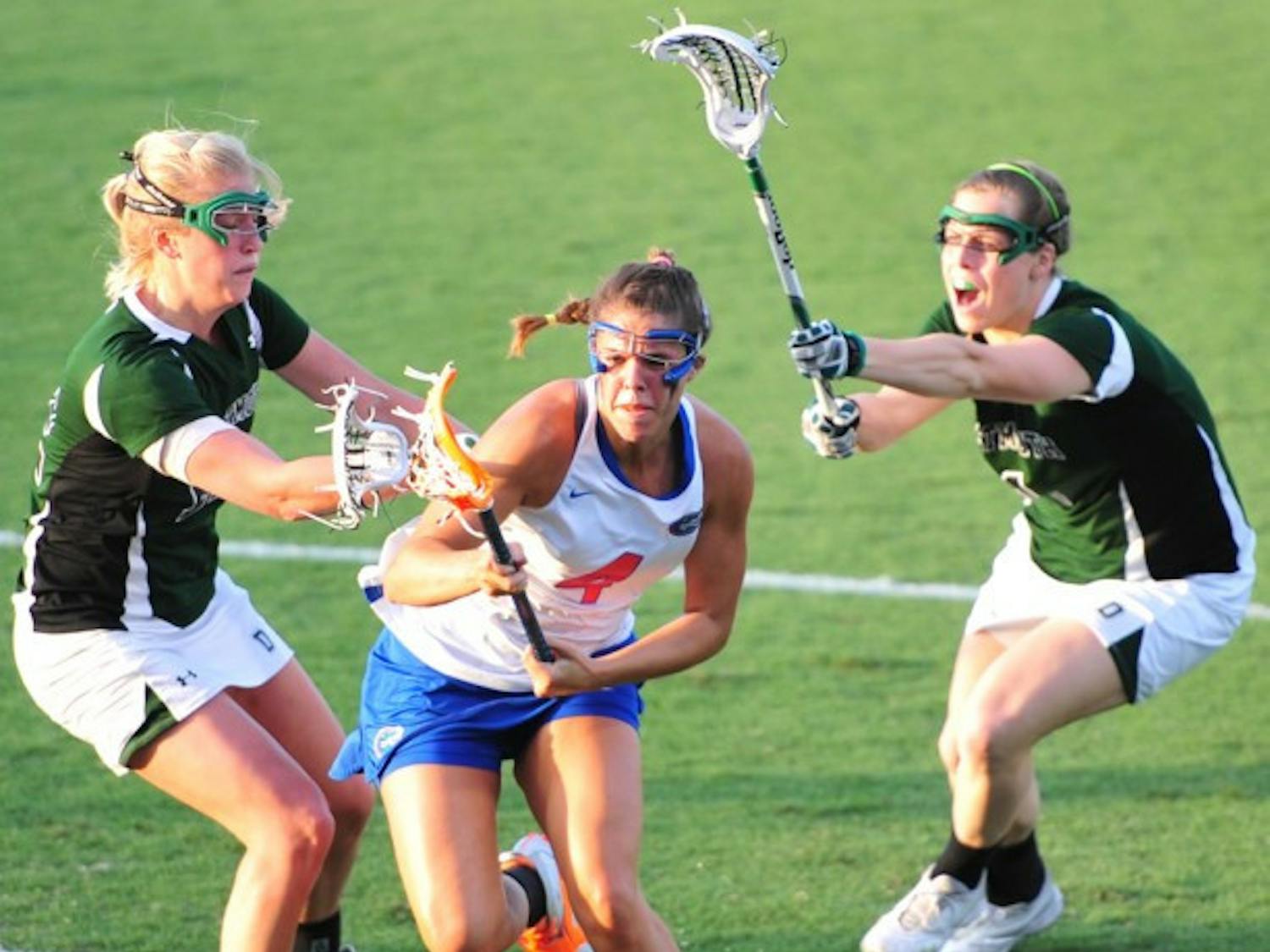 Florida attacker Kitty Cullen splits two Dartmouth defenders while attacking the goal during the Gators’ 20-4 win against the Big Green on Tuesday. Cullen scored five goals.