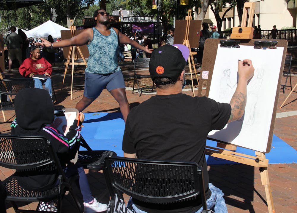 Amarisa Harrison-Conwill, (left) 5, and her father Mo Harrison-Conwill (right) draw during the 40th Downtown Festival & Art Show at Bo Diddley Plaza on Sunday, Nov. 7, 2021. "Daddy's an artist," Amarisa said.