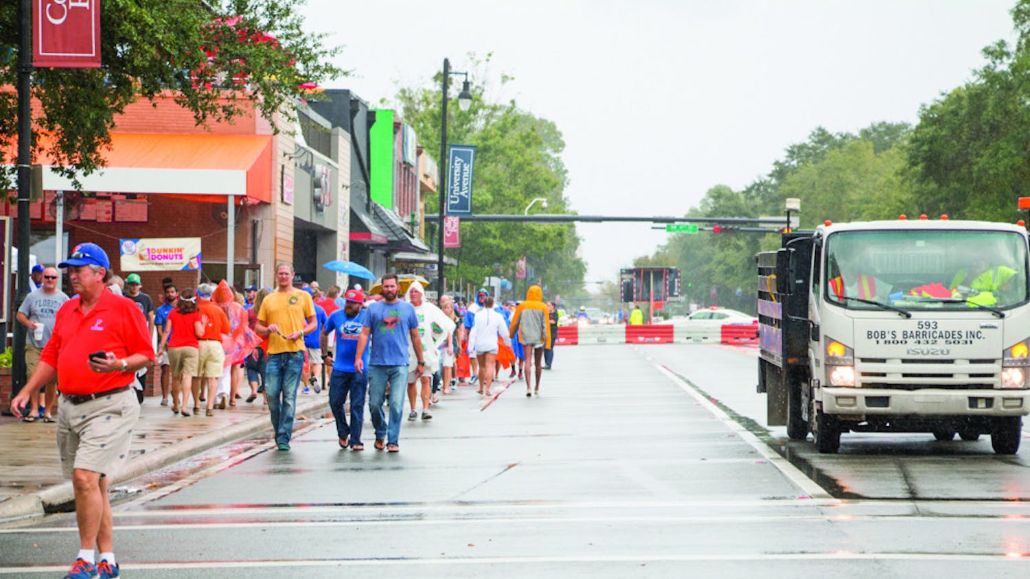 Despite the rain, fans walk down the closed-off University Avenue to Ben Hill Griffin Stadium on Saturday afternoon for the UF Homecoming football game.