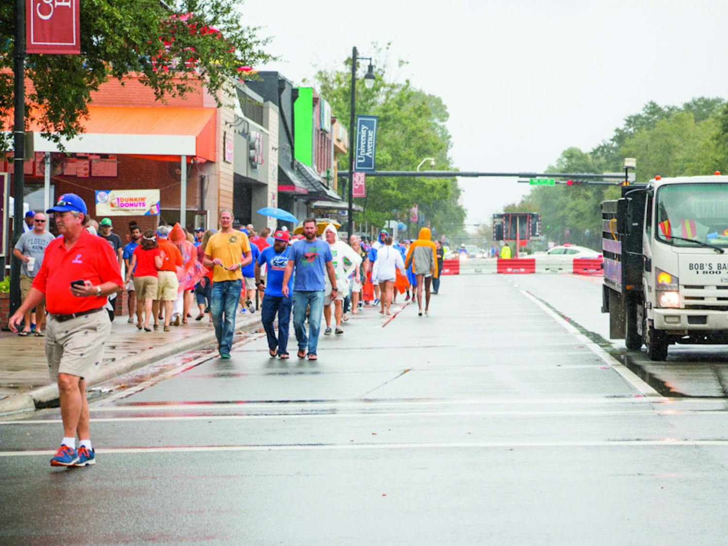 Despite the rain, fans walk down the closed-off University Avenue to Ben Hill Griffin Stadium on Saturday afternoon for the UF Homecoming football game.