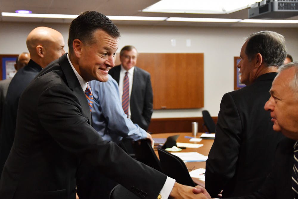<p>Scott Stricklin (left) greets members of the UAA board on Sept. 27, 2016.</p>