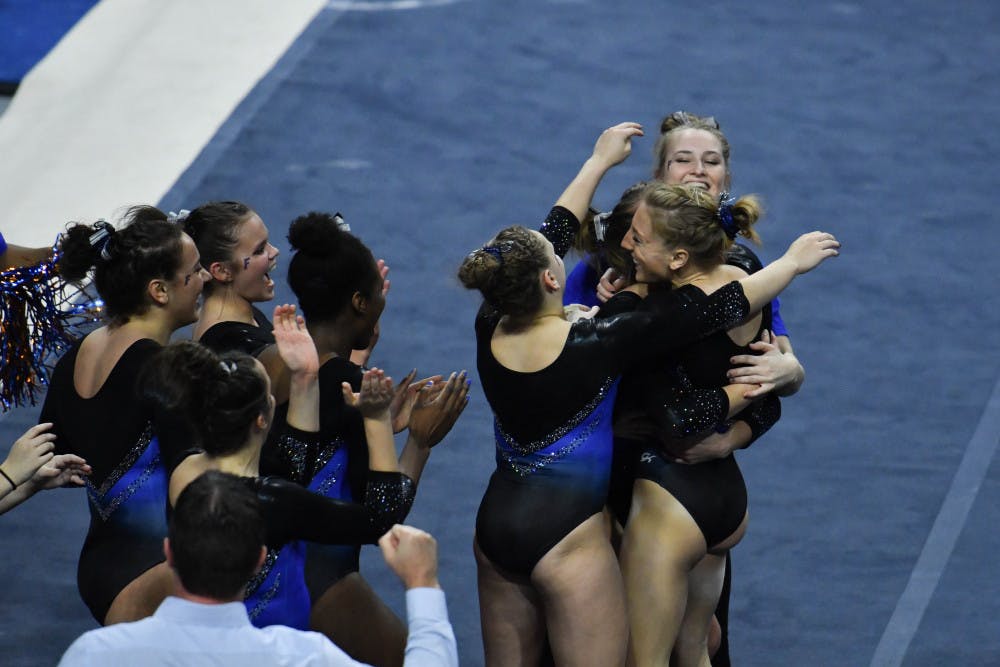 <p>Alex McMurtry (bottom right) hugs her teammates after her floor routine during Florida's win over Missouri on Jan. 24, 2017. McMurtry's routine received a perfect 10. </p>