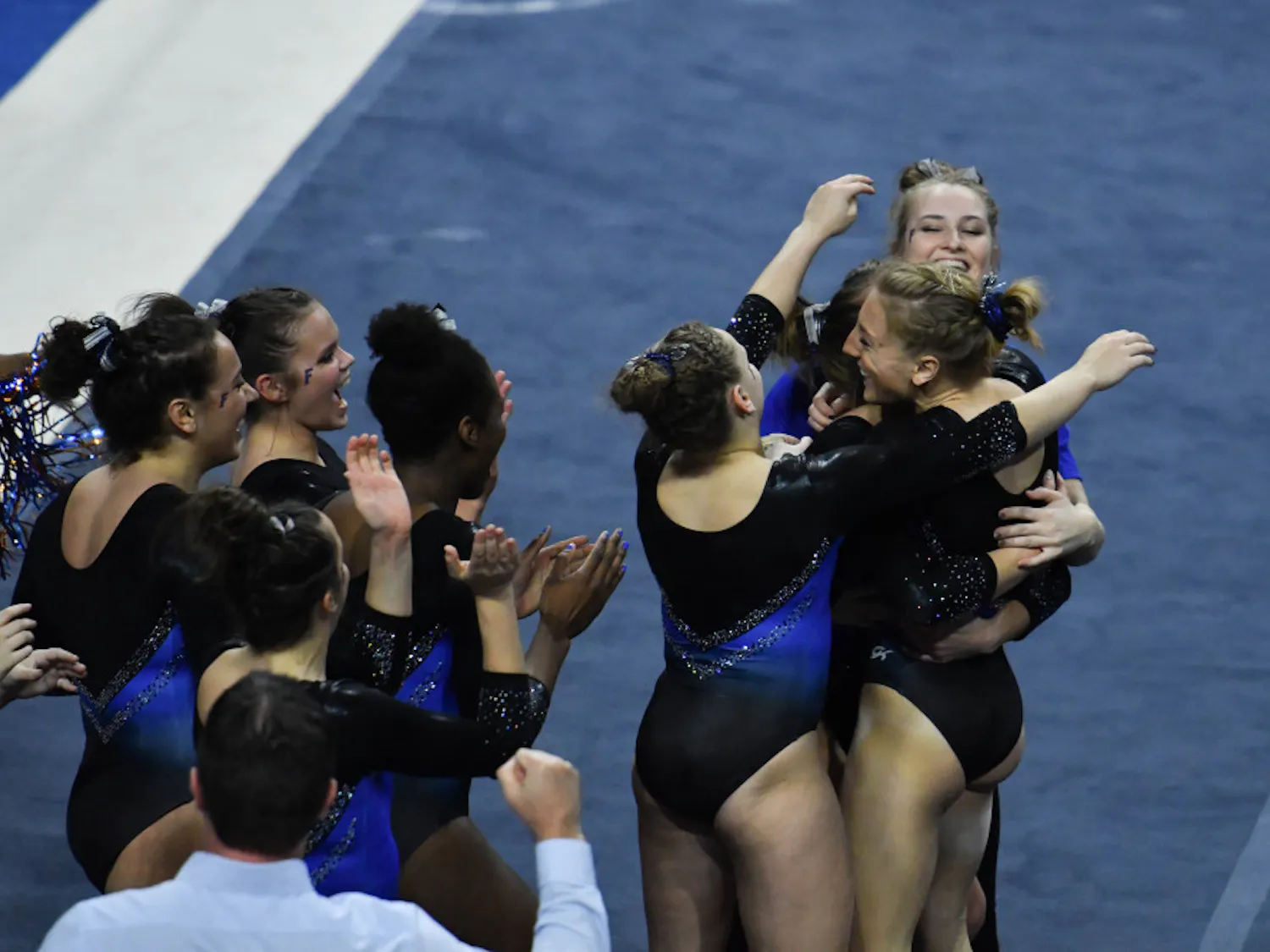 Alex McMurtry (bottom right) hugs her teammates after her floor routine during Florida's win over Missouri on Jan. 24, 2017. McMurtry's routine received a perfect 10.