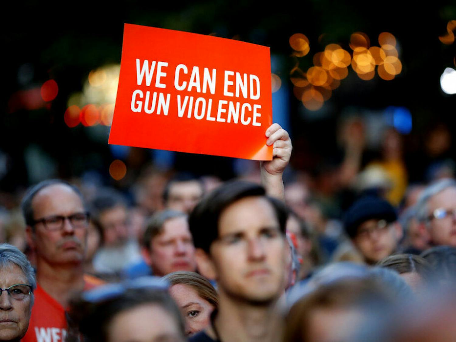 Mourners gather for a vigil at the scene of a mass shooting, Sunday, Aug. 4, 2019, in Dayton, Ohio. A masked gunman in body armor opened fire early Sunday in the popular entertainment district in Dayton, killing several people, including his sister, and wounding dozens before he was quickly slain by police, officials said. (AP Photo/John Minchillo