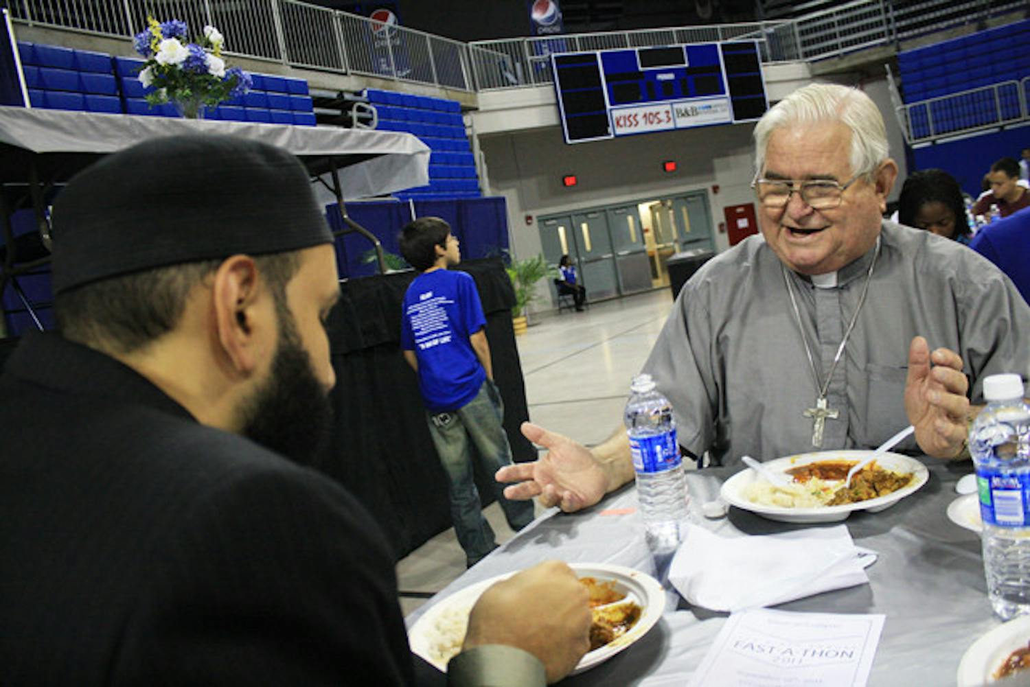 Imam Omar Suleiman and Father Les Singleton discuss differences in faith over dinner at Islam on Campus' Fast-A-Thon. "To say you're an atheist is to deny a part of yourself," Singleton said as he described "Mere Christianity," a book by C. S. Lewis, to Suleiman.