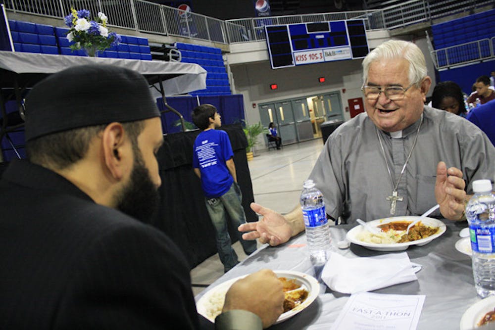 <p>Imam Omar Suleiman and Father Les Singleton discuss differences in faith over dinner at Islam on Campus' Fast-A-Thon. "To say you're an atheist is to deny a part of yourself," Singleton said as he described "Mere Christianity," a book by C. S. Lewis, to Suleiman.</p>