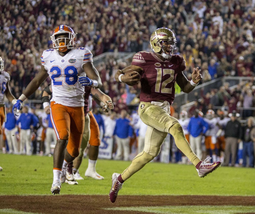 Florida State quarterback Deondre Francois reacts to scoring a touchdown in front of Florida linebacker Kylan Johnson during the second half of an NCAA college football game in Tallahassee, Fla., Saturday, Nov. 26, 2016. Florida State defeated Florida 33-13. (AP Photo/Mark Wallheiser)