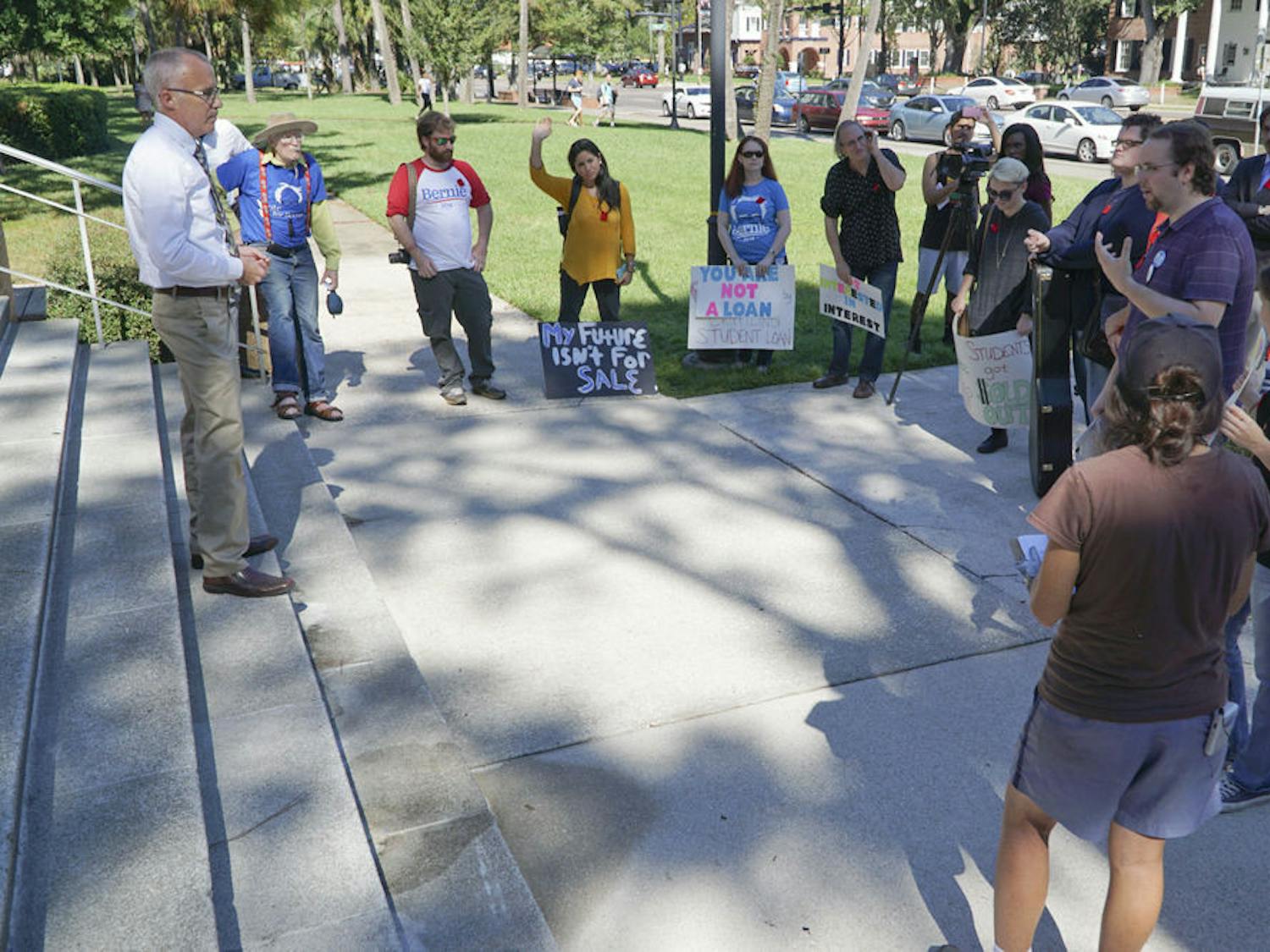 UF spokesman Steve Orlando (left) addresses about a dozen protesters participating in the nationwide Million Student March outside Tigert Hall on Nov. 12, 2015. Students and Gainesville locals protested rising tuition, loan debt and low-wage jobs offered to them after leaving school.