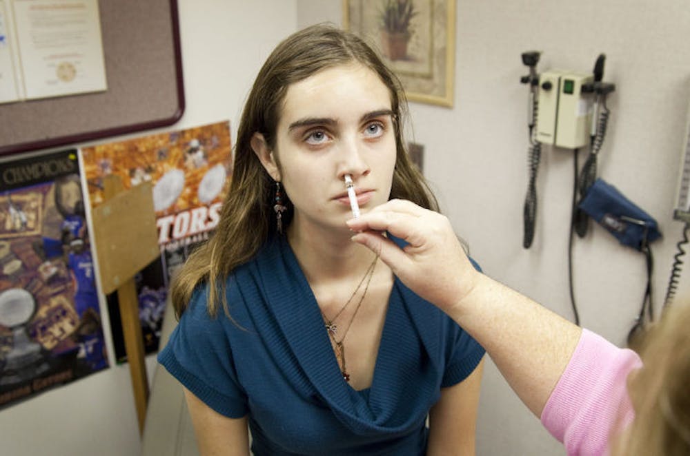 <p>UF student Victoria Reynolds receives a nasal spray vaccine for H1N1 during a mass vaccination of 800 students throughout Wednesday at the Infirmary.</p>