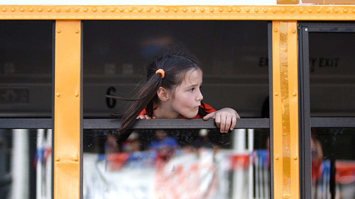 A girl stares out the window of an Alachua County school bus on West University Avenue.