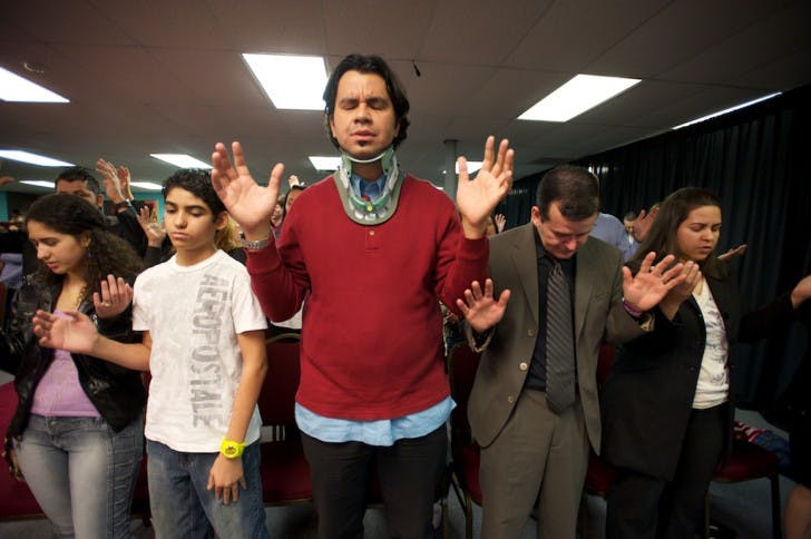 Marietta, Ga. - Jessika and Jefferson Carmo, 17 and 13, whose father died in the Interstate 75 wrecks, stand with Joilson Lima, 34, a survivor of the wrecks, and Fabio Souza, 41, the current caretaker of 15-year-old Lidiane Carmo during a Sunday afternoon service at the International Church of the Restoration. Lidiane is still at Shands at UF in the company of Souza's wife.