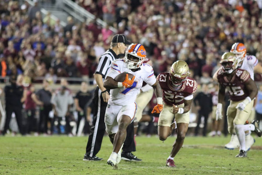 <p>Florida freshman running back Trevor Etienne carries the ball against the Florida State Seminoles Friday, Nov. 25, 2022. Etienne carried the ball 17 time for 129 yards — including a 45-yard touchdown. </p>
