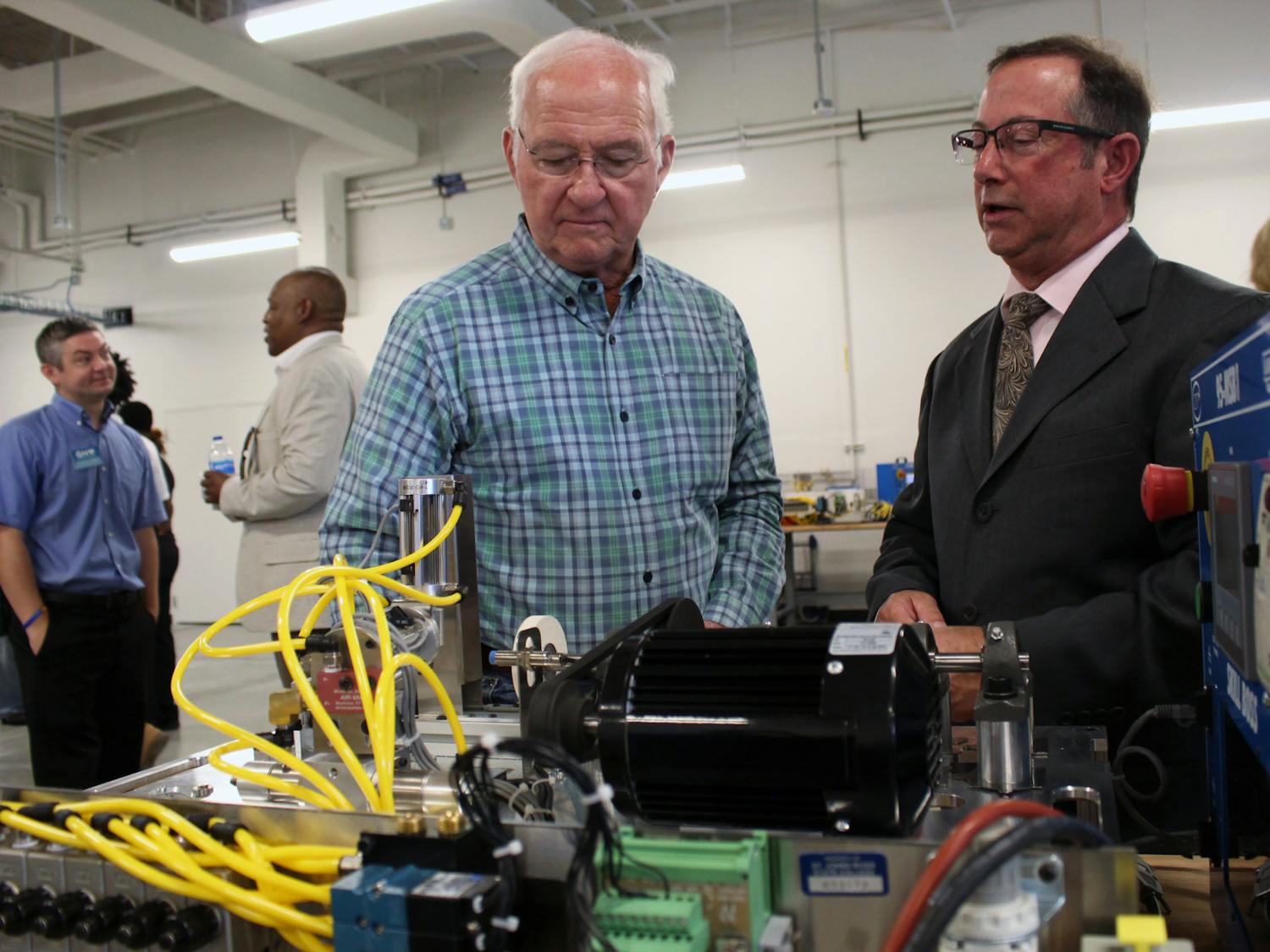 Jim Emerson (right) listens as Professor Mark Terrone (left) explains one of the displays at the open house for the Ralph W. Cellon Jr. Institute for Skilled Trades and Advanced Manufacturing on Tuesday, August 19, 2025.