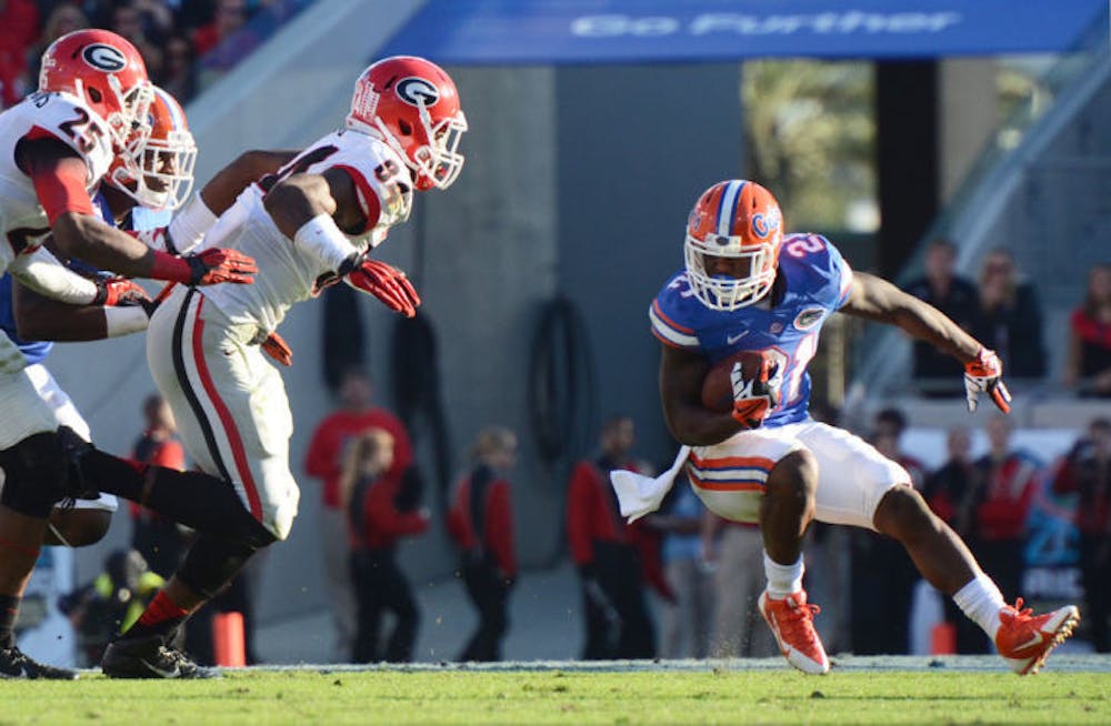 <p>Kelvin Taylor (21) makes a cut while running the ball during Florida’s 23-20 loss to Georgia on Nov. 2 at EverBank Field in Jacksonville. The UF running back ran for 508 yards and four touchdowns in 2013.</p>