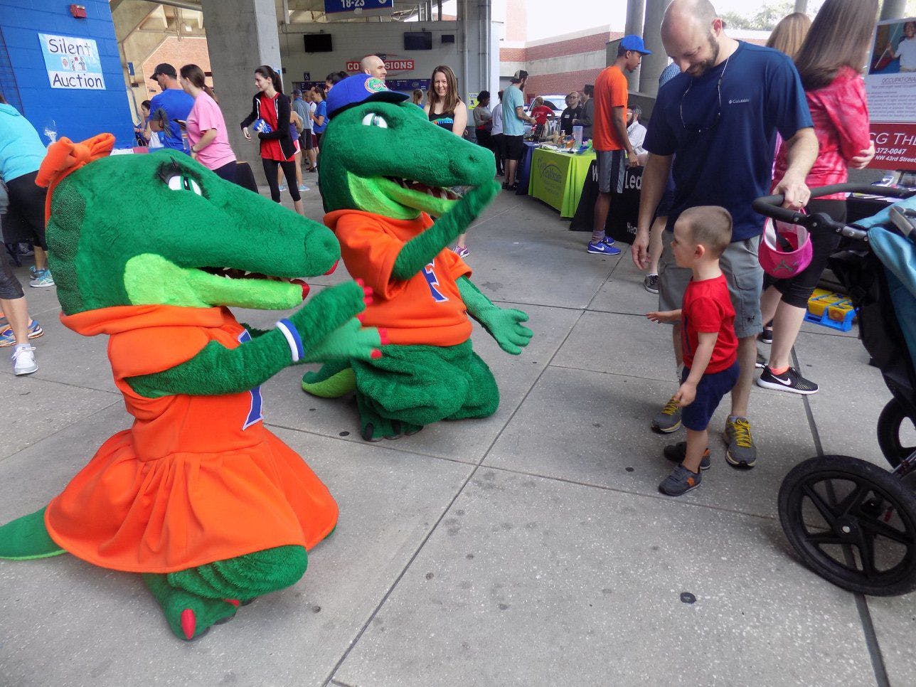 Albert and Alberta show their Gator spirit by chomping and playing with a child before attendees started to run laps around Ben Hill Griffin Stadium.