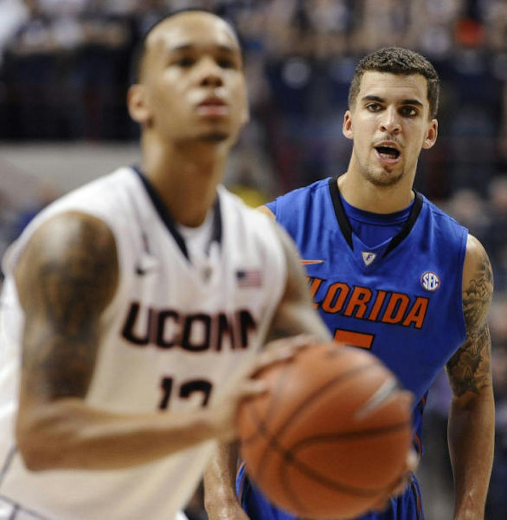 <p>Scottie Wilbekin (right) watches Connecticut’s Shabazz Napier shoot a free throw during the first half of the Gators’ 65-64 loss to the Huskies on Monday night in Storrs, Conn.</p>