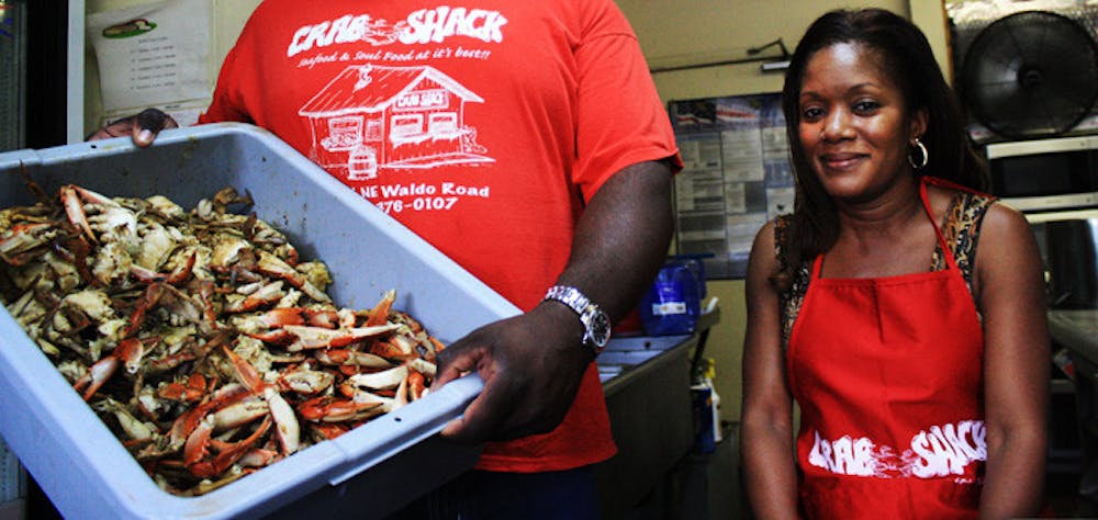<p>Marcus Brinson and LaShundra Coley pose for a picture inside the Crab Shack. Brinson, the manager of the restaurant at 104 NE Waldo Road, is holding a tub of fresh crabs that Crab Shack serves to local</p>
<p>customers every day. The restaurant is known for its family-first atmosphere, with only direct family and family friends working at the shack. That family-based dynamic has led to a constant stream of regular customers. "You wouldn't know there was a recession going on," Coley said. "Crab Shack doesn't stop."</p>