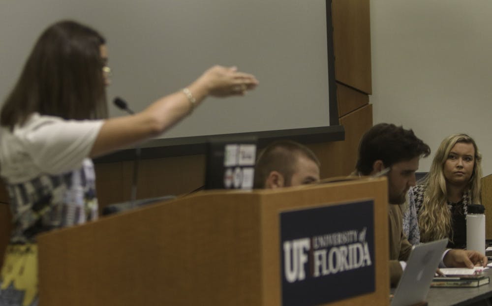 Libby Shaw (right), senate president for University of Florida student government, receives criticism Tuesday during public comment over the removal of Inspire Senators Ashley Grabowski, the former senate minority leader, and Ben Lima. Eight people read statements from students, alumni and UF staff disagreeing with Shaws actions and asking for the reinstatement of Grabowski and Lima.