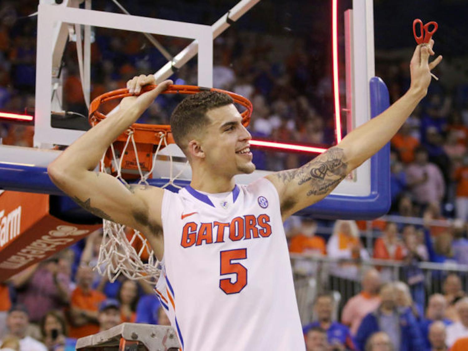 Scottie Wilbekin cuts down the net after Florida’s 84-65 win against Kentucky on Saturday in the O’Connell Center.