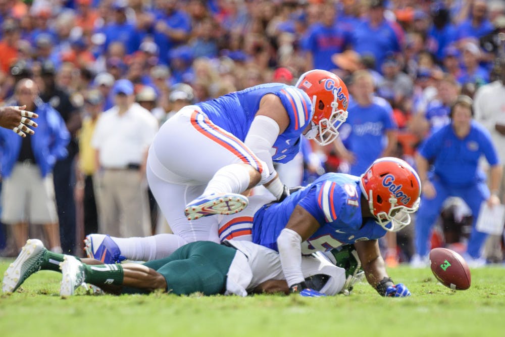 <p>Michael Taylor and Caleb Brantly force Eastern Michigan quarterback Reginald Bell to fumble the ball during the Gators' 65-0 win against the Eagles on Saturday at Ben Hill Griffin Stadium.</p>