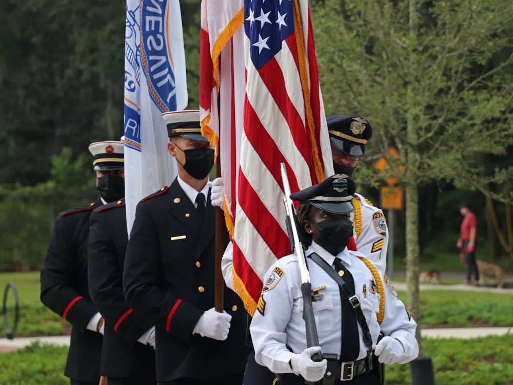 The Gainesville Fire Rescue and Gainesville Police Department joint honor guard does a presentation of colors at Reserve Park on Saturday, Sept. 11, 2021. The three flags represent the city, state and country (from left to right).