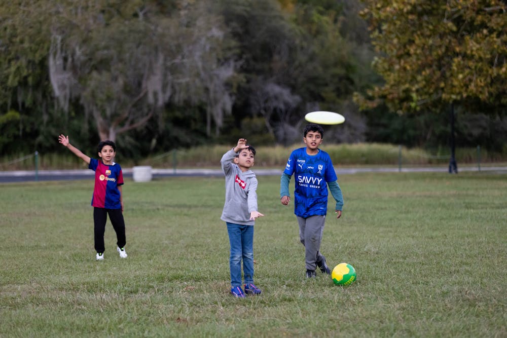 Michael Taino plays frisbee with kids to spread kindness in Gainesville on Friday, Oct. 31, 2025.