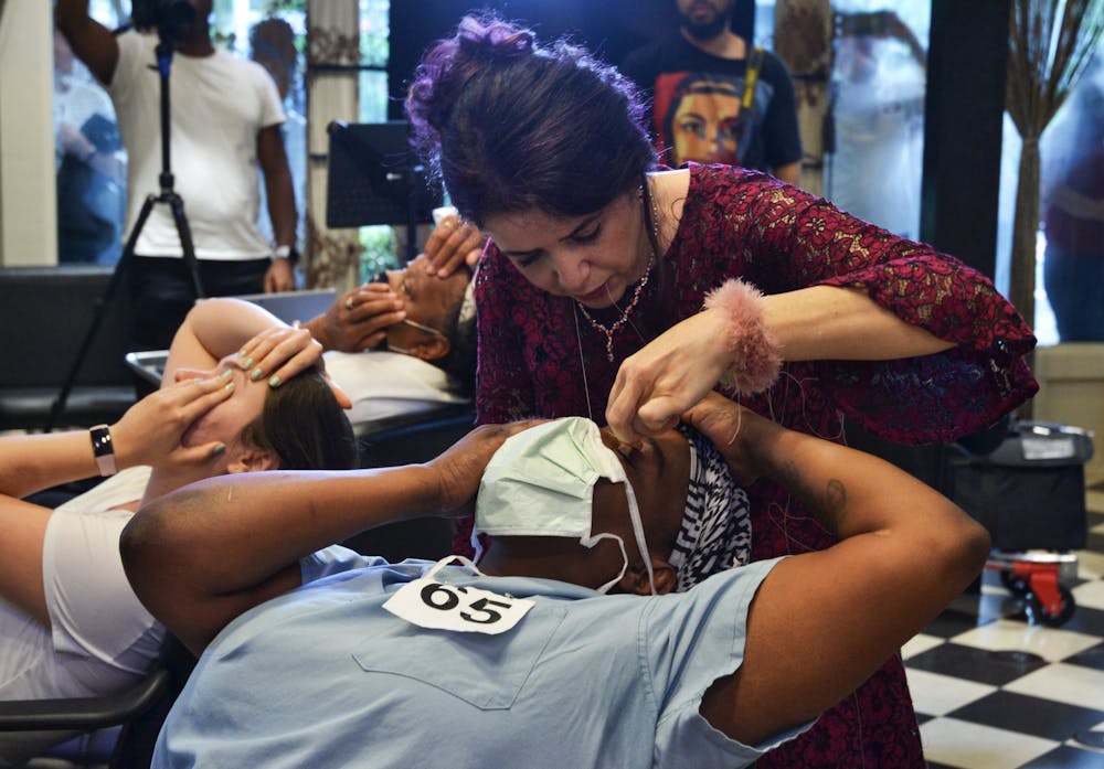Ziba Ahmadi, owner of Salon Ziba in Gainesville, threads Shavonne Carter's eyebrows, and breaks the previous record for most eyebrows threaded by one person in one hour on Wednesday, June 16, 2021.