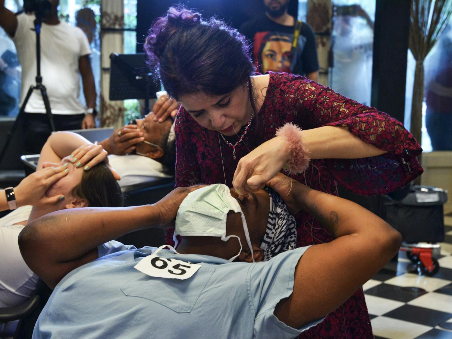 Ziba Ahmadi, owner of Salon Ziba in Gainesville, threads Shavonne Carter's eyebrows, and breaks the previous record for most eyebrows threaded by one person in one hour on Wednesday, June 16, 2021.