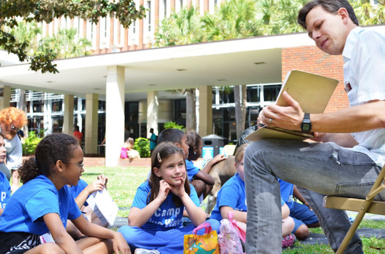 UF film and media studies doctoral student Anthony Coman, 32, reads to P. K. Yonge Developmental Research School students Tuesday afternoon on the Plaza of the Americas. The event is the first of the three-day ReadFest and part of National Library Week.