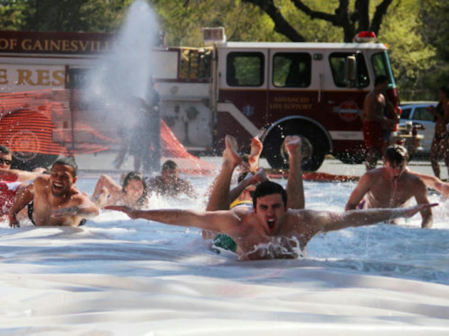 UF students enjoy a 100-foot Slip ‘N Slide at the Pi Kappa Alpha house on West University Avenue on Friday afternoon. This event served as a Dance Marathon check-in point, and all proceeds will go to the Children’s Miracle Network.