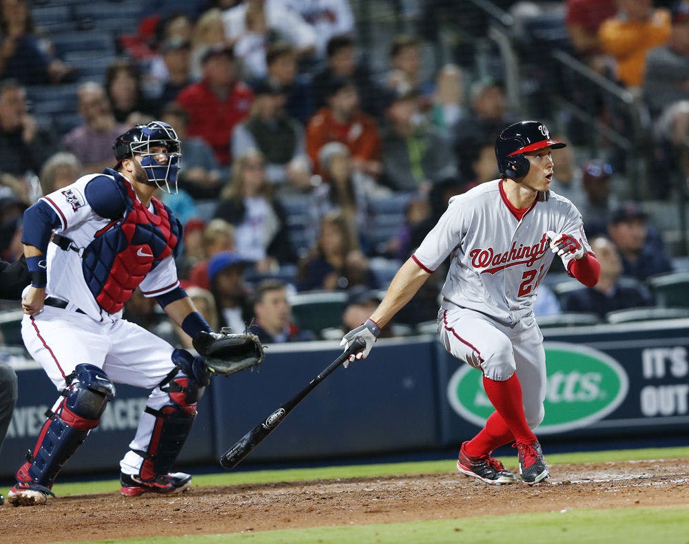 Washington Nationals pinch hitter Matt den Dekker (21) follows through on a two-run double as Atlanta Braves catcher A.J. Pierzynski (15) looks on in the seventh inning of a baseball game Wednesday, April 6, 2016, in Atlanta, Georgia.