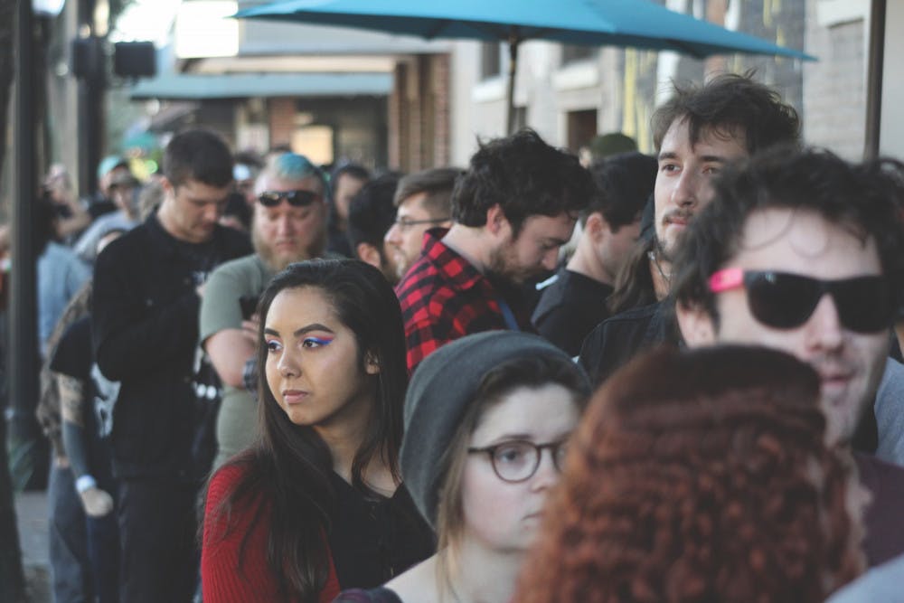 Fest 16 attendees wait in a line outside The Wooly on Sunday. They were waiting to see the artist Into It. Over it.