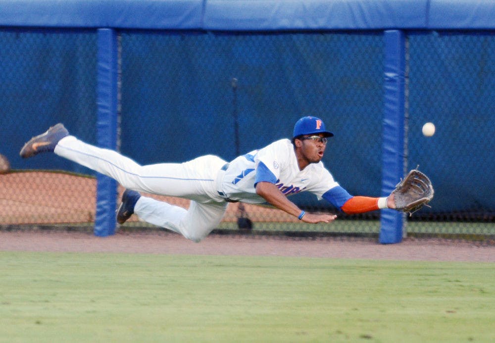 <p>Buddy Reed dives to catch a ball in the outfield during Florida's win against Florida A&amp;M in the 2015 NCAA Regionals.</p>