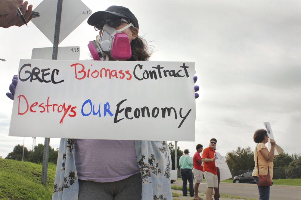 <p>Maria Parsons, a Gainesville resident, protests at the corner of Northwest 39th Avenue and Northwest 97th Boulevard on Aug. 30, 2015. Her gas mask and gloves symbolize the pollution she said the biomass plant causes.</p>