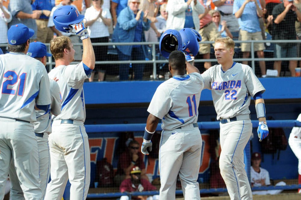 <p>JJ Schwarz celebrates with teammates at home plate after hitting the first of his two home runs during Florida's 11-4 win against Florida State on June 6, 2015, at McKethan Stadium.</p>
